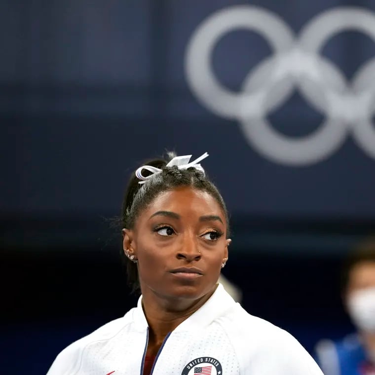 FILE - In this July 27, 2021 file photo, Simone Biles, of the United States, watches gymnasts perform after she exited the team final at the 2020 Summer Olympics, in Tokyo. Biles, who redefined excellence in gymnastics and picked up seven Olympic medals along the way, drew attention and, from some, criticism by pulling out of events in Tokyo because of a mental block that made her afraid to attempt certain dangerous moves. (AP Photo/Ashley Landis, File)