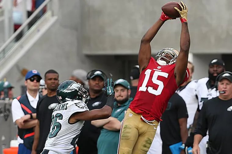 The 49ers' Michael Crabtree (right) catches a pass as the Cary Williams defends. (David Maialetti/Staff Photographer)