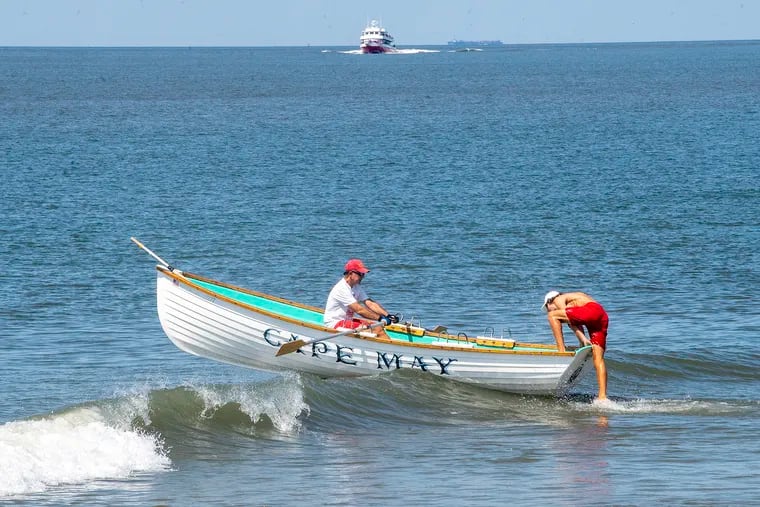 Cape May lifeguards paddle their surf boat against the waves last month.