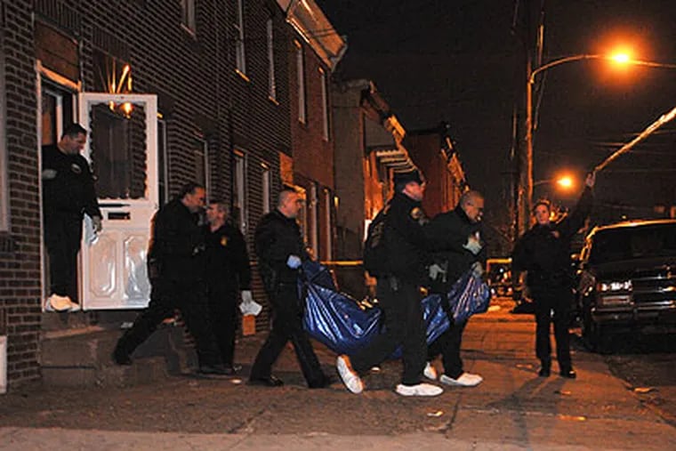 Philadelphia detectives carry the body of a woman from a house on C Street off of Somerset. It is not known if her death is connected to the Kensington strangler, but it is in the same area. (Sharon Gekoski-Kimmel / Staff Photographer)