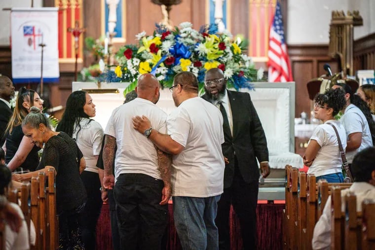 Family members stand together during the funeral of Eddie Irizarry, at Christ and Saint Ambrose Episcopal Church.