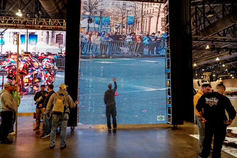 January 1, 2024: A  large TV screen that will be their backdrop shows scenes from last year’s Mummers Parade, as the Golden Crown Fancy Brigade tests their staging at the Convention Center, preparing for the division’s two finale performances on New Year’s Day with ticketed shows, at 11:30 a.m. and 5 p.m.