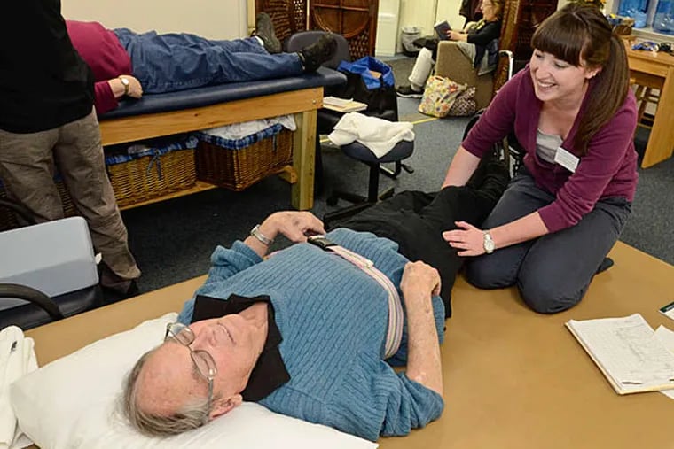 Courtney Christman, a physical therapy student at the clinic at Widener University, helps Bill Weir with a leg problem. The clinic, run by graduate students, is free to Chester residents. (Ron Tarver/Staff)