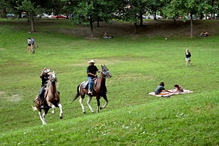 August 2, 2021: Chris Coger (left) on Shadow and Malik Divers astride Big Sunny ride in Clark Park in West Philadelphia. Divers rides out of the brand-new Concrete Cowboys stables at Bartram's Garden. (He coined the term for his horse-riding program more than a decade ago, before the Idris Elba movie that took the same title rather than use that of the book, "Ghetto Cowboy," it was based on.)