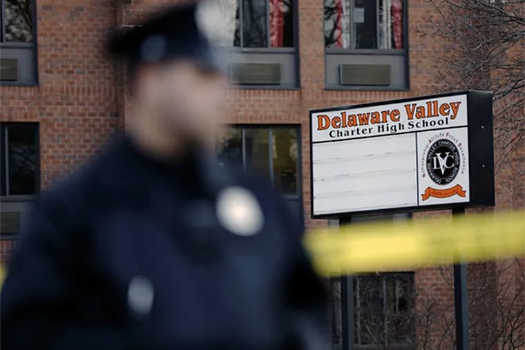A police officer stands by caution tape at the Delaware Valley Charter School Friday, Jan. 17, 2014. (AP Photo/Matt Rourke)