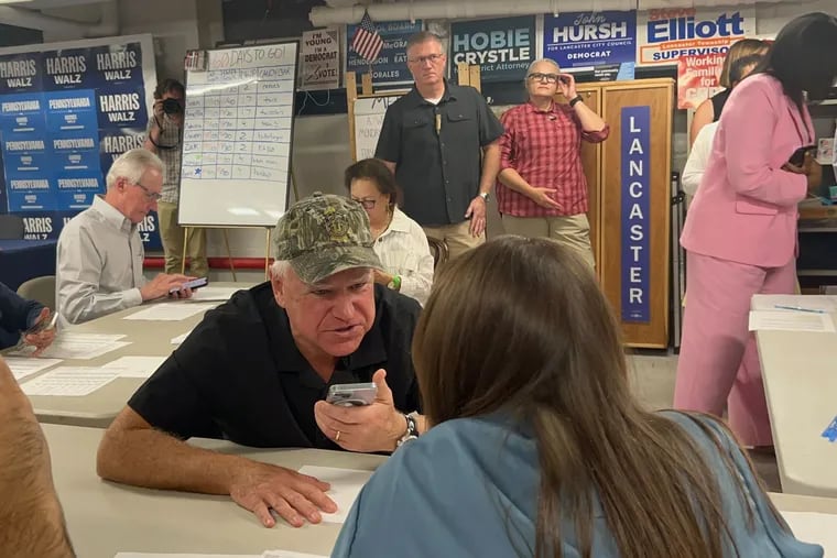 Minnesota Gov. Tim Walz speaks on the phone to a voter in Lancaster County while visiting the campaign's field office on Wednesday.