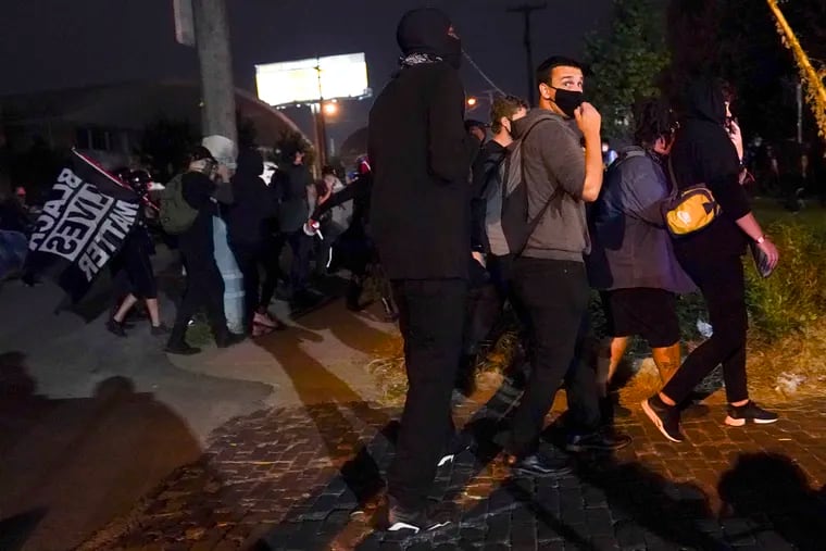 Protesters react to gunfire Wednesday in Louisville, Ky.