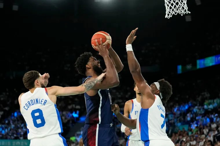 Joel Embiid (11) goes to the basket under pressure from French players Isaia Cordinier (8) and Guerschon Yabusele (7) during the men's gold medal basketball game at Bercy Arena at the 2024 Summer Olympics, on Saturday.