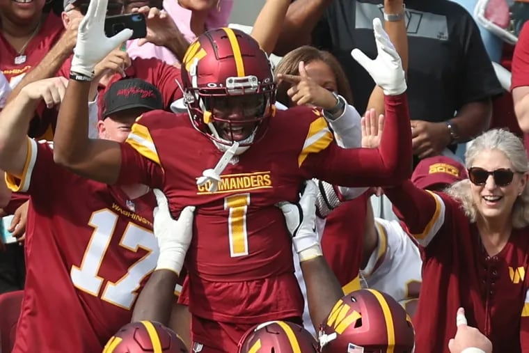 Washington Commanders wide receiver Jahan Dotson hops into the FedEx Field stands to celebrate a touchdown against the Eagles on Oct. 29, 2023.