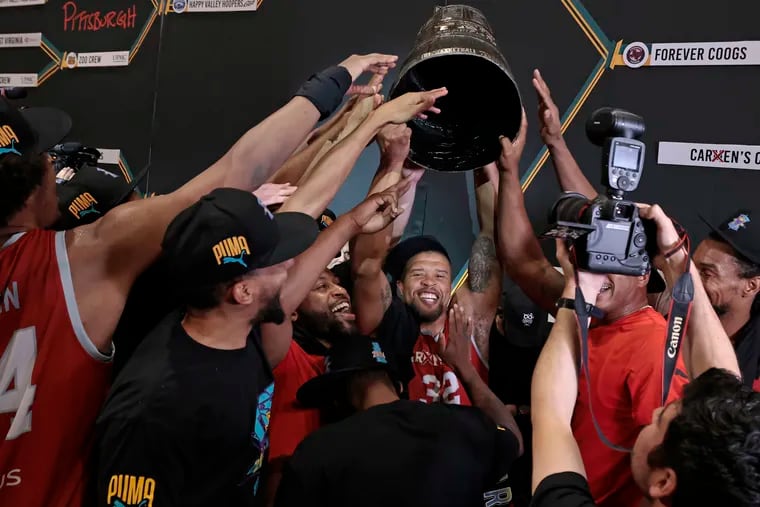 Jeff Gibbs  (32) of Carmen’s Crew  holds up the trophy as he and his teammates celebrate winning the TBT $1 Million Championship.