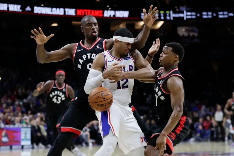Sixers forward Tobias Harris gets double-teamed late in the fourth quarter by Toronto forward Serge Ibaka (left) and guard Kyle Lowry.