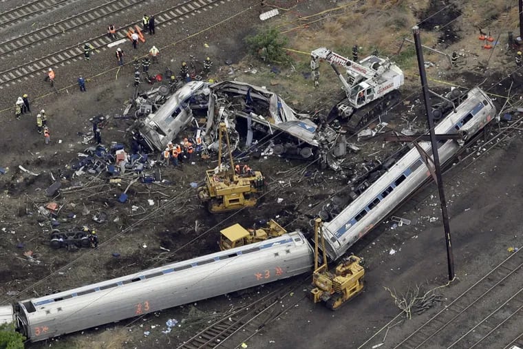 Emergency personnel work near the wreckage of a New York City-bound Amtrak passenger train following a derailment that killed eight people and injured about 200 others in Philadelphia.