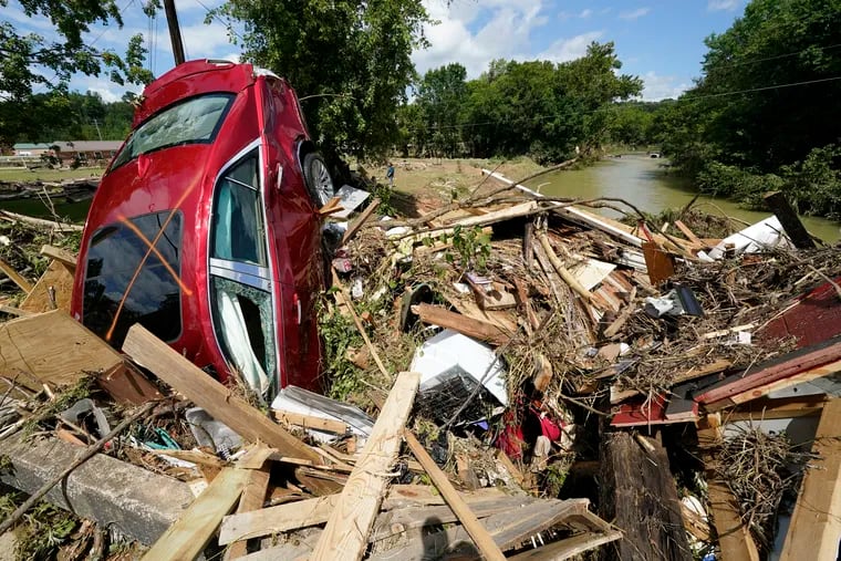 A car is among debris that washed up against a bridge over a stream Sunday in Waverly, Tenn.