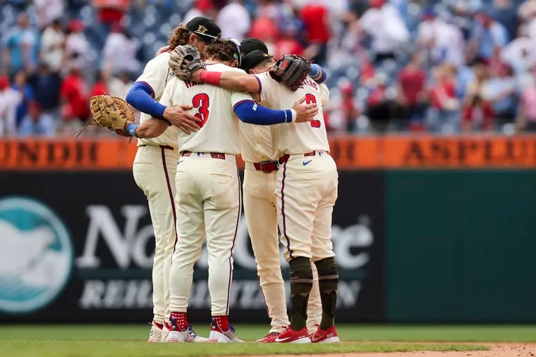 Members of the Phillies gather for a hug after defeating the Washington Nationals at Citizens Bank Park in May. It’s refreshing and deeply moving to hear players describe the brotherly affection that knits their team together, Kyle Hulehan writes.