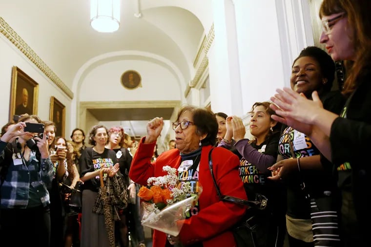 Mercedes Reyes (center) a live-in domestic worker and leader within the Pennsylvania Domestic Workers Alliance, cheers with other advocates after City Council passed a bill expanding labor protections for domestic workers.