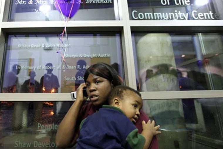Shantell Thomas talks on the phone as she holds her son, Jabari Bartlett, while the two attend an Anti-Violence Night at the Homan Square Community Center in North Lawndale, Illinois. (Heather Charles / Chicago Tribune/MCT)