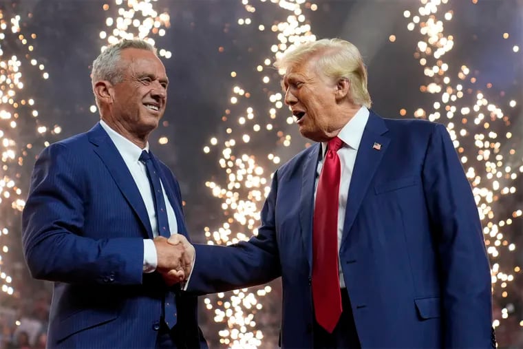 Republican presidential nominee former President Donald Trump shakes hands with independent presidential candidate Robert F. Kennedy Jr. at a campaign rally Friday in Glendale, Ariz.