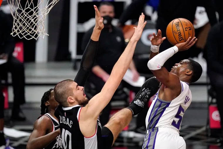 Sacramento Kings guard De'Aaron Fox (right) shoots as Los Angeles Clippers center Ivica Zubac defends during a game on Sunday.