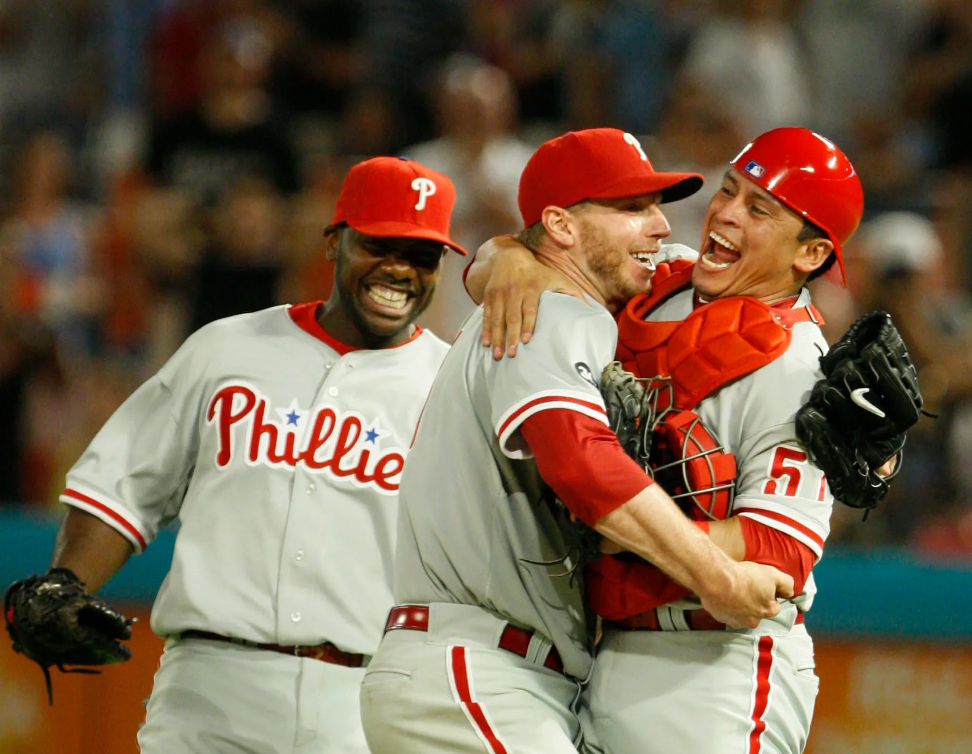 Philadelphia Phillies starting pitcher Roy Halladay, center, celebrates with Carlos Ruiz, right, and Ryan Howard after Halladay threw a perfect game against the Florida Marlins on May 29, 2010.