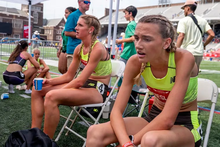 Penn Charter’s Alli DeLisi (left) and Haverford’s Olivia Cieslak take a break after they competed in their 800-meter heat at the New Balance Nationals at Franklin Field.