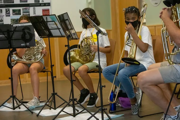 Chrysyn Harp, a 7th grader at the Girard Academic Music Program, playing trombone with Brass Chamber Ensemble  at the All-City Orchestra Summer Academy at Mann Music Center on July 27. Mask wearing at school can be challenging, but it's essential, doctors say.