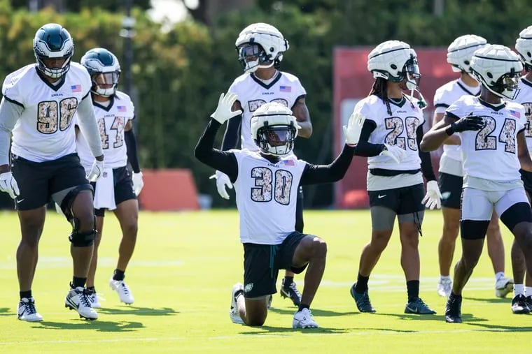 Quinyon Mitchell (30) and Eagles teammates warm up and stretch at the beginning of practice during the Eagles training camp at the Novacare Complex on Saturday.