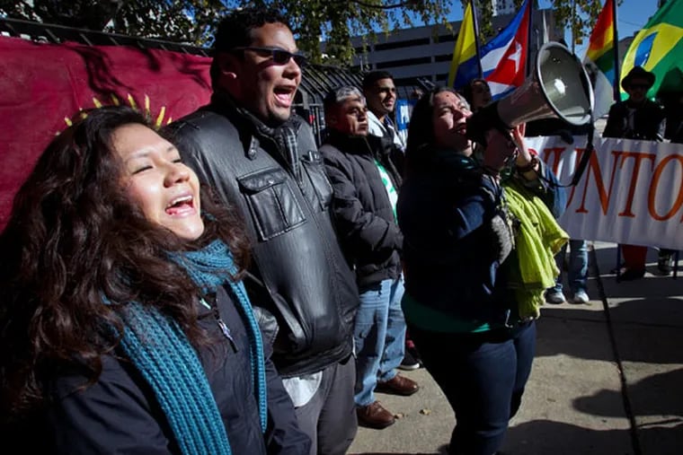 Juntos members (from left) Olivia Vasquez, Miguel Andrade and Erika Almiron during a rally outside immigration offices at North 16th and Callowhill streets on Friday, November 21, 2014.