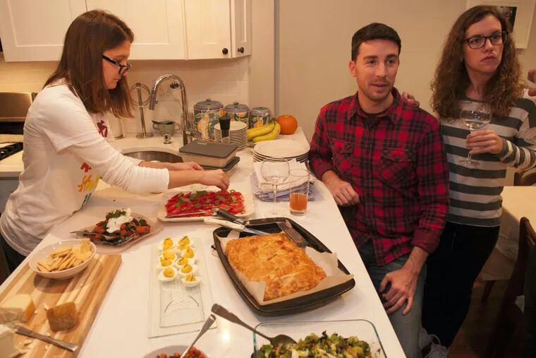 Attending a potluck party are (from left) Erica Stone, Adam Falkowitz, and Ashley Wertman.