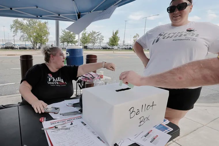 Unite Here Local 274 members and Aramark workers Randi Trent (left) and Samantha Spector look on as coworkers place their ballots in the ballot box during a strike authorization vote prior to Sunday's game at Citizens Bank Park between the Phillies and the Braves.