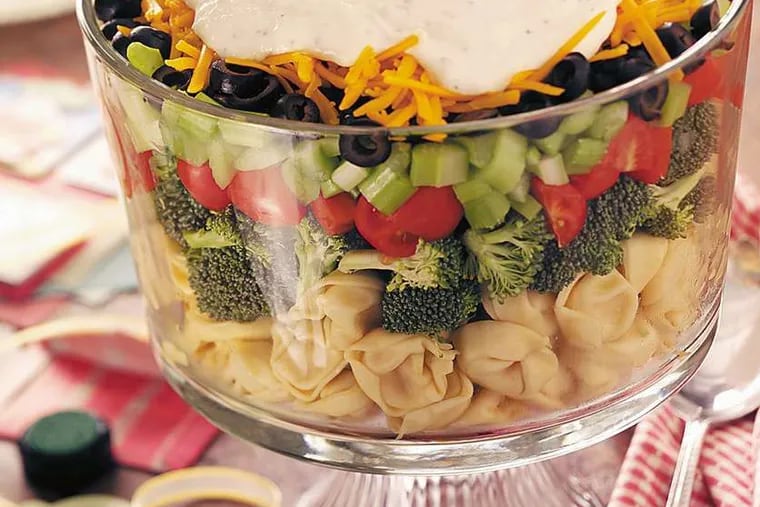 Cheese tortellini adds another dimension to this seven-layer salad topped with a Parmesan dressing.