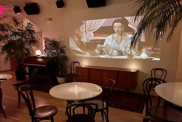 A movie plays on a wall on the second floor of Say No More in December.