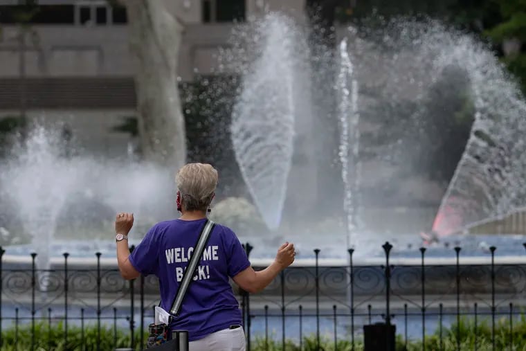 Cari Feiler Bender dances during the fountain show at Franklin Square in Philadelphia on Monday, the day the park reopened to the public, including Philly Mini Golf, Parx Liberty Carousel, both playgrounds, and SquareBurger.