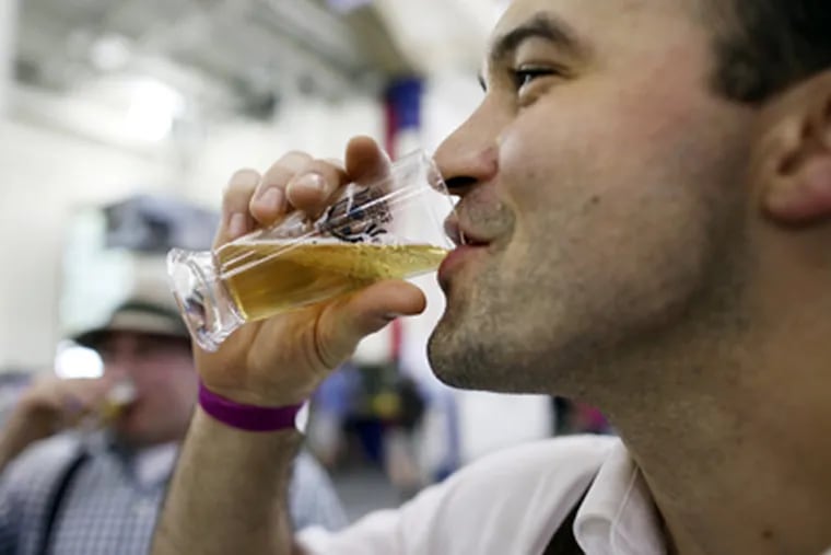 Jason Suda, from Philadelphia, tips his glass at the International Great Beer Expo at the Navy Yard in Philadelphia on Saturday. (Laurence Kesterson / Staff Photographer)