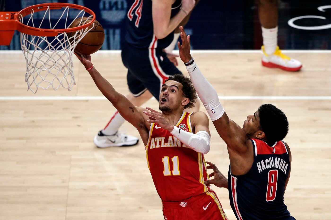 Atlanta Hawks guard Trae Young lays in a bucket as Washington Wizards forward Rui Hachimura defends.