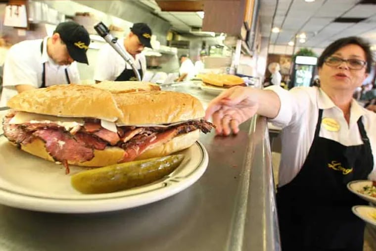 Sheila Abramson, a waitress at Langer's Delicatessen in Los Angeles, California, reaches out for a plate while serving customers on National Pastrami Day on January 14, 2013. Delis are on declining in number, and even landmark locations aren't immune to the industry slide. (Mel Melcon/Los Angeles Times/MCT)