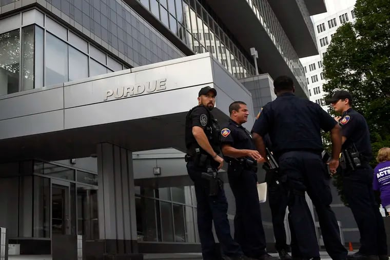 In this Aug. 17, 2018 photo, Stamford Police stand outside the headquarters of Purdue Pharma, which is owned by the Sackler family, in Stamford, Conn. The Sackler family came under scrutiny when a legal filing in Massachusetts gave detailed allegations of how family members and other Purdue Pharma executives sought to push prescriptions for the drug OxyContin and downplay its addiction risks. (AP Photo/Jessica Hill)