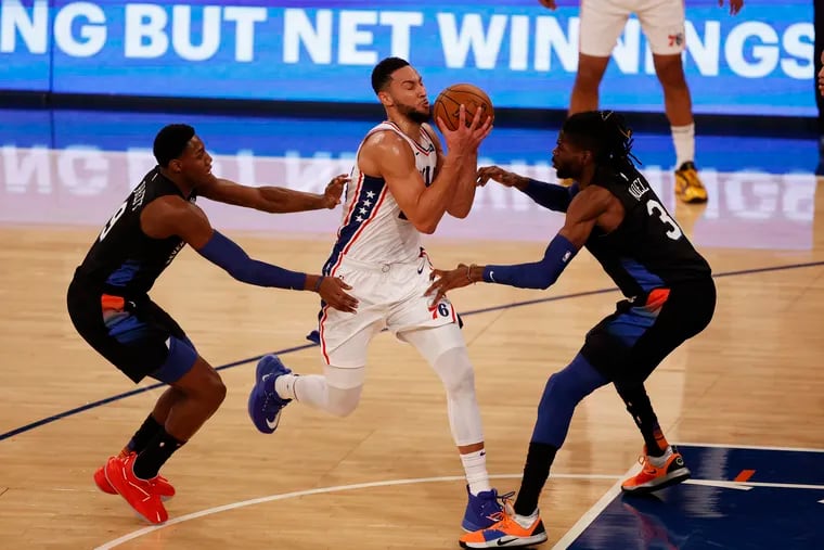 76ers guard Ben Simmons drives to the basket between Knicks center Nerlens Noel (right) and guard RJ Barrett Saturday.