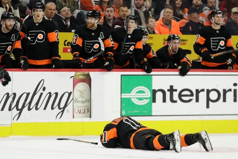 Travis Konecny lies on the ice after absorbing an open-ice hit Saturday against the Ottawa Senators.
