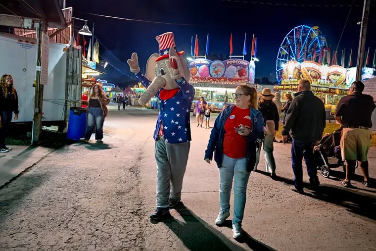 T.J. Fitzgerald wears an elephant costume at the Luzerne Country Fair in Lehman on Sept. 4 while working at a booth with the Luzerne County Republicans. Escorting him along the midway is Nichole Blair.