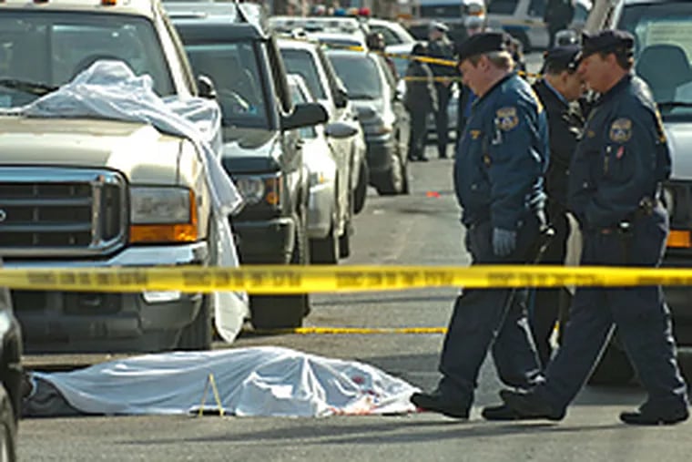 Philadelphia crime scene investigators walk around the body of a man shot and killed by plainclothes police officers at 16th and Swain. (Clem Murray/Inquirer)