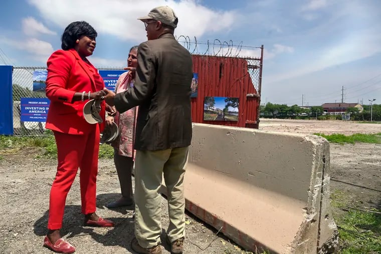 Mayor Cherelle L. Parker talks with Bartram’s Garden executive director Maitreyi Roy (center) and board president Charles Lomax on Monday following a U.S. Environmental Protection Agency announcement of $2 million to clean up the old 49th Street Terminal (rear), a contaminated site in Southwest Philadelphia.