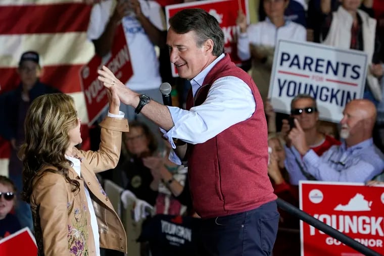 Republican gubernatorial candidate Glenn Youngkin, right, gives his wife Suzanne, a high five during a rally in Chesterfield, Va., Monday, Nov. 1, 2021. Youngkin will face Democrat former Gov. Terry McAuliffe in the November election. (AP Photo/Steve Helber)