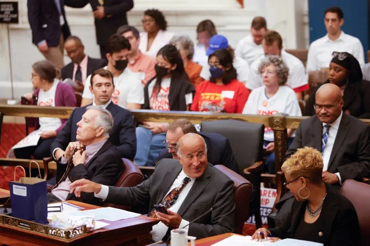 City Councilmember Mark Squilla (front center) speaks to Councilmember Cindy Bass at the first meeting of Council's fall session. Activists opposed to the 76ers' arena proposal look on from the audience.