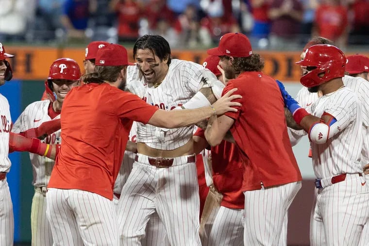 Nick Castellanos, center, is swarmed by his Phillies teammates after hitting a walk-off double in the 10th inning.