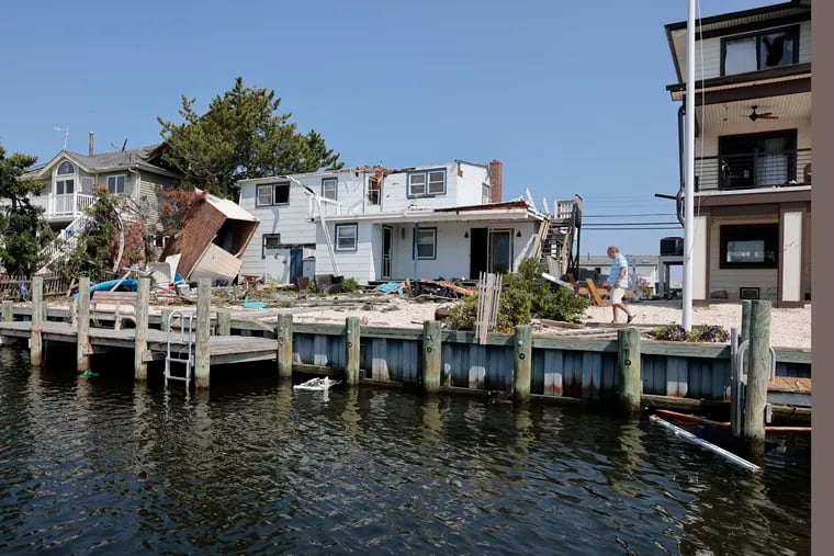 People begin assessing the damage left behind on  Arnold Blvd. in the High Bar Harbor section of Long Beach Township on Friday. Destructive storms that included tornados left their marks in both Pennsylvania and New Jersey