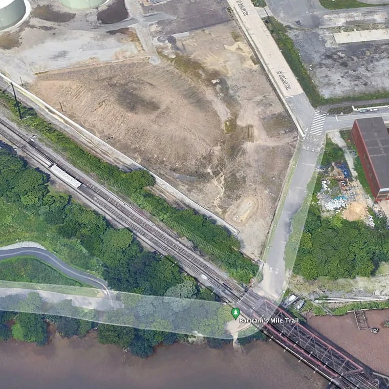 Satellite imagery from Google Earth appears to show a length of yellowish discharge running parallel to railroad tracks off Bartram's Mile Trail in Philadelphia in August 2018. Sediment also appears to be spilling onto the trail.