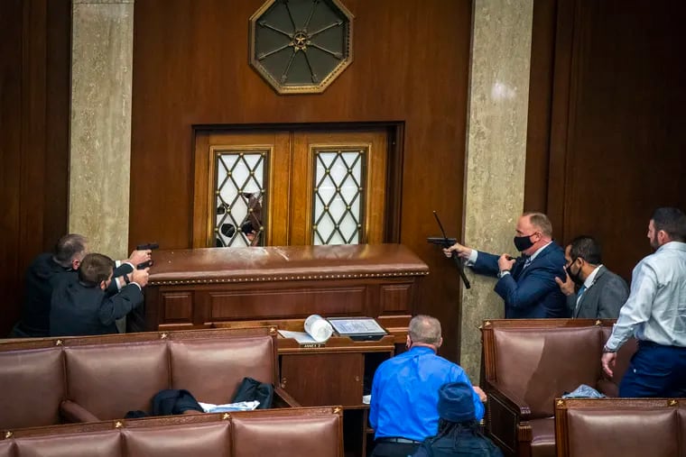 Security officers point weapons at a House chamber door as a mob of rioters storms the Capitol on Wednesday.