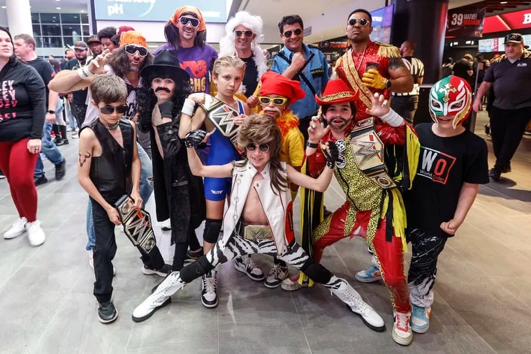 From left to right, dads Anthony Bucci, dressed as Macho Man Randy Savage, Todd Staples, also dressed as Macho Man, Eric Iverson, as Ric Flair, Scott Ritterman, as Big Boss Man, and Seth George, as Montez Ford, pose with their sons at WWE Monday Night Raw at the Wells Fargo Center.