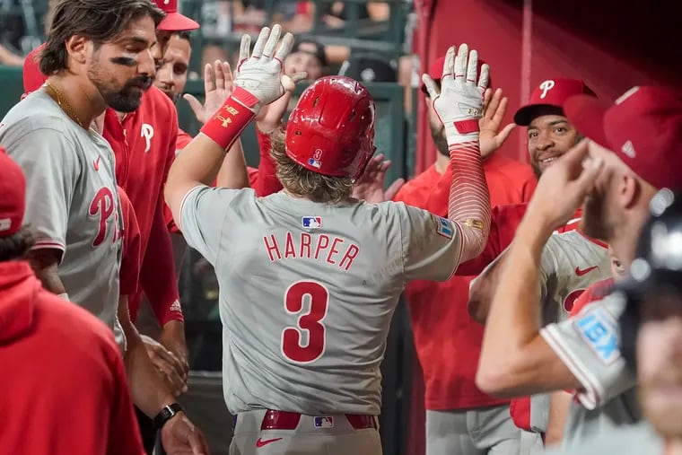 Bryce Harper gets high-fives from teammates after hitting a solo home run against the Arizona Diamondbacks in the seventh inning.