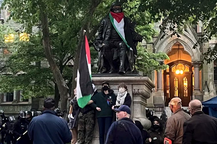 Protesters lock arms at the Benjamin Franklin Statue on Penn's campus as police clear the pro-Palestinian encampment.